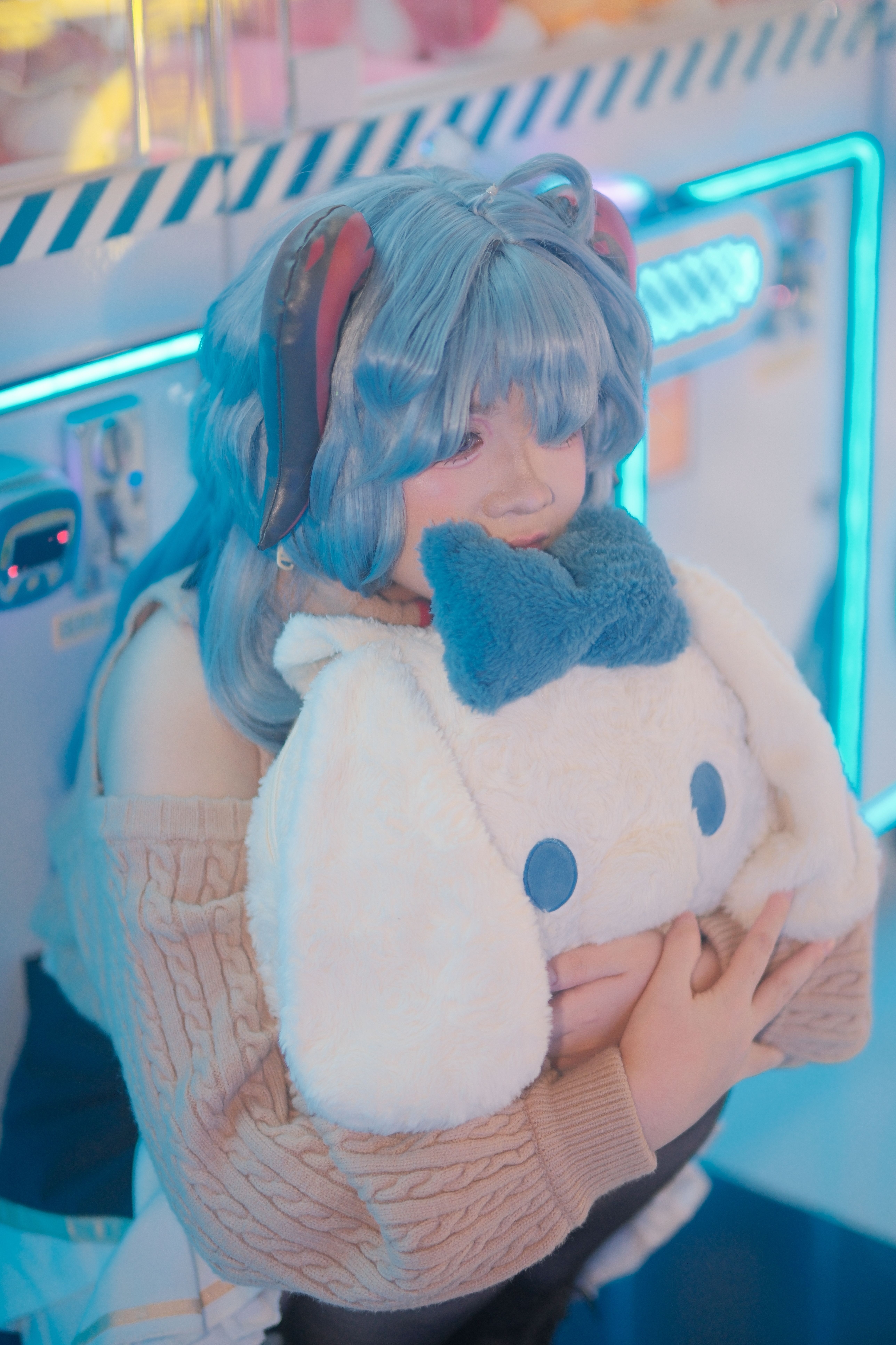A person in cosplay hugging a plush toy near a neon-lit claw machine, creating a playful and futuristic atmosphere.