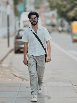 Young man in casual attire walking down a street in Thiruvananthapuram, India.