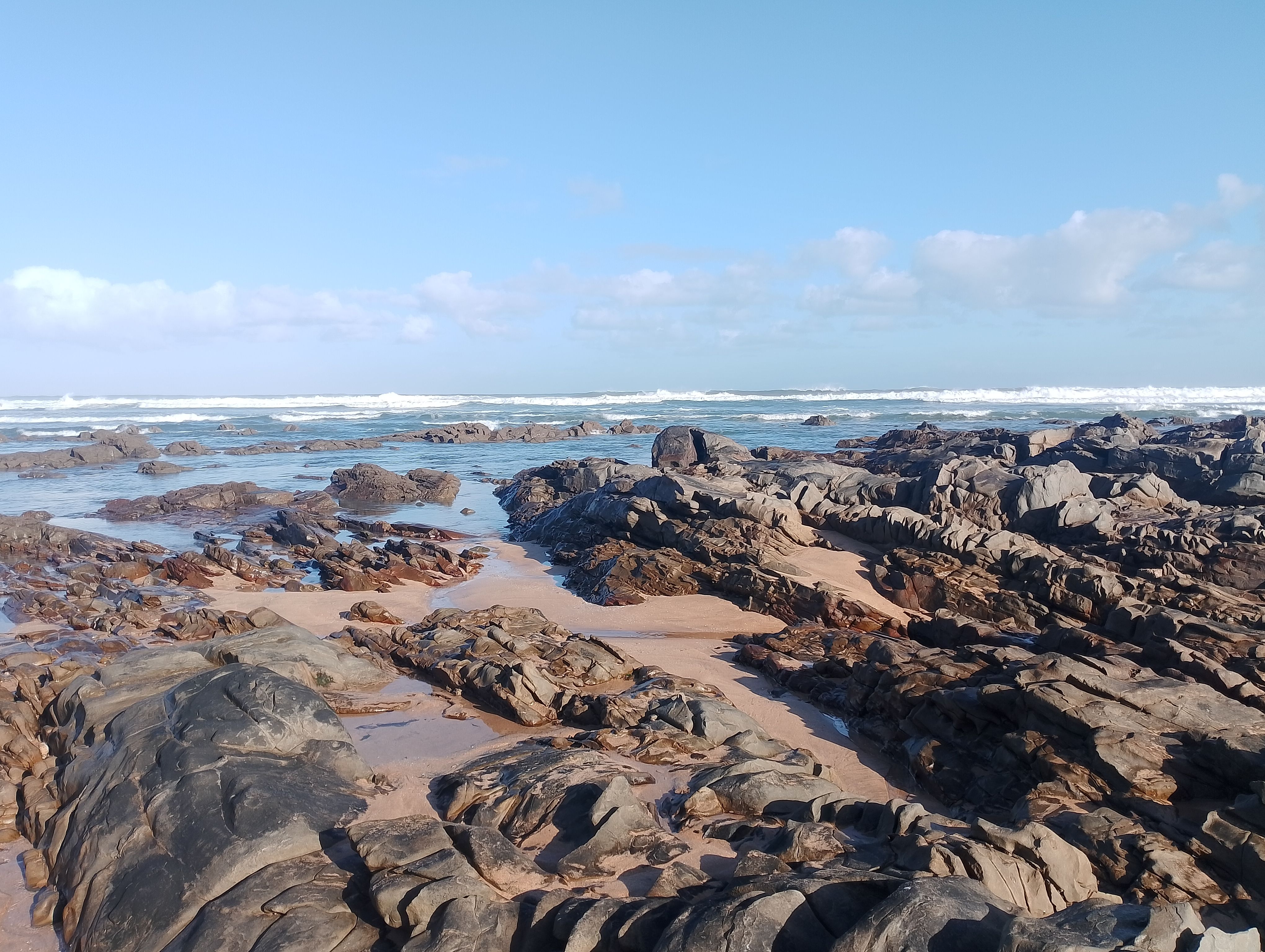 Rocky Shoreline with Ocean Waves and Blue Sky · Free Stock Photo