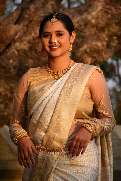 Free Portrait of a woman in traditional Indian attire with ornate jewelry, smiling warmly outdoors. Stock Photo