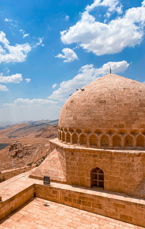 Free Majestic stone dome in Mardin, Türkiye, with a clear blue sky and distant hills. Stock Photo