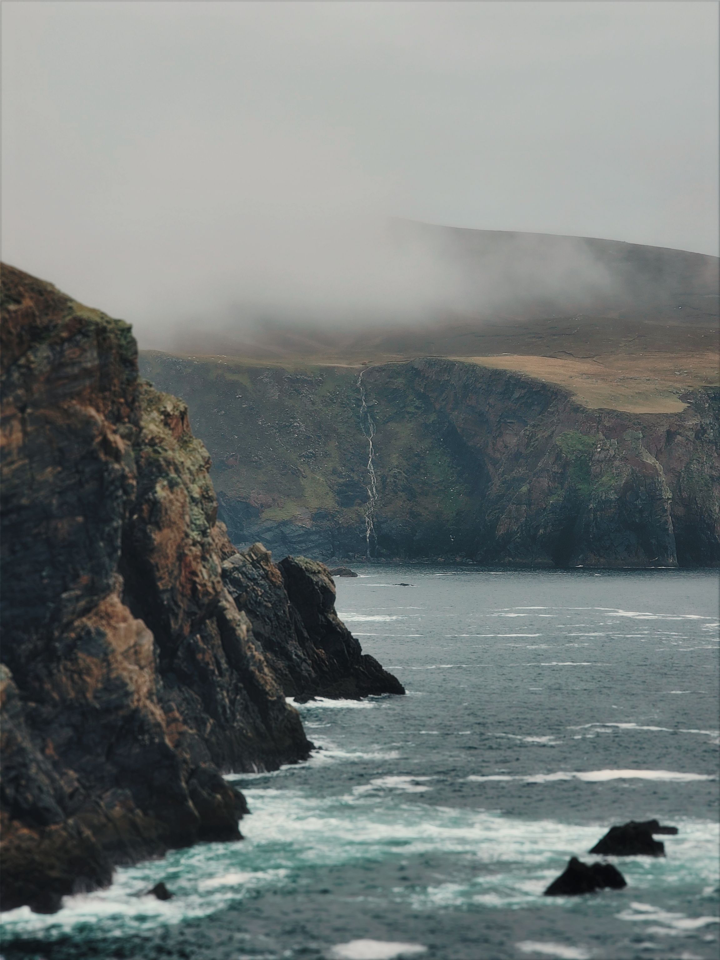 Dramatic Coastal Cliffs with Misty Backdrop · Free Stock Photo