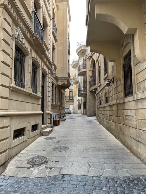 Free Charming narrow alleyway with historic architecture in Baku's old city, showcasing elegant stone buildings. Stock Photo