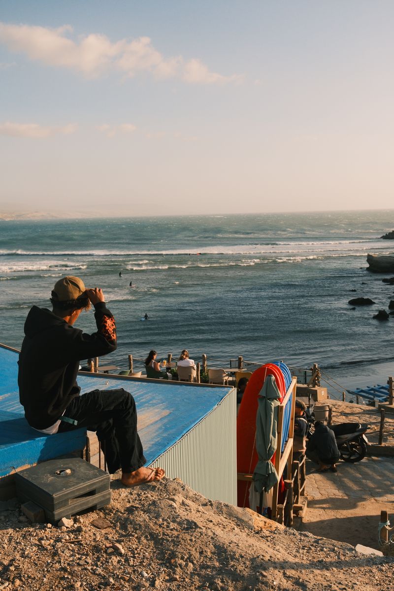 Person watching ocean waves rooftop Morocco