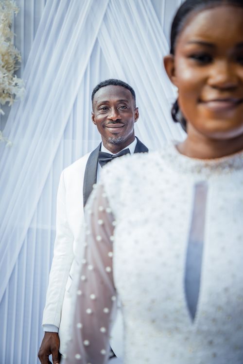 Free Bride and groom in elegant white outfits pose together on their wedding day. Stock Photo