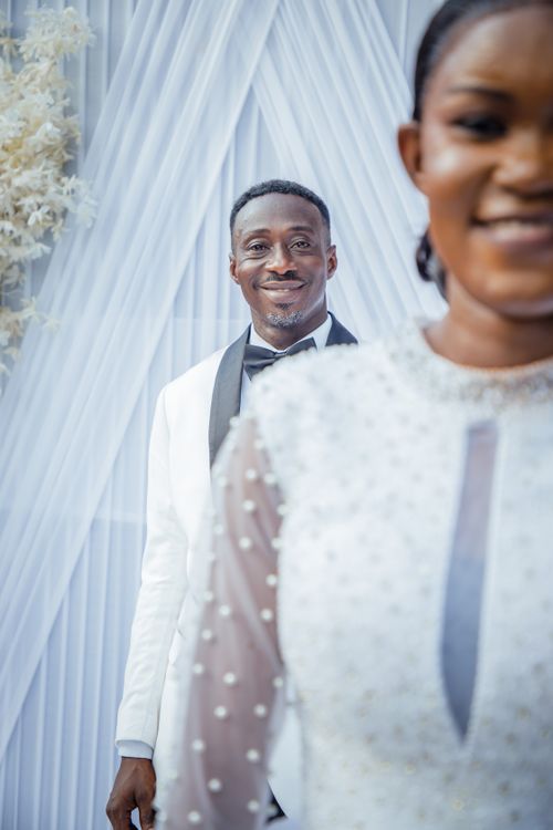 Free A joyful wedding couple in elegant white attire celebrating their special day indoors. Stock Photo