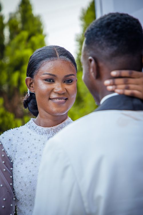 Free A bride and groom share a heartfelt moment on their wedding day outdoors. Stock Photo