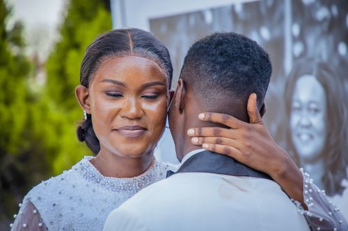 Free Close-up of a couple sharing a tender embrace during a wedding ceremony outdoors. Stock Photo
