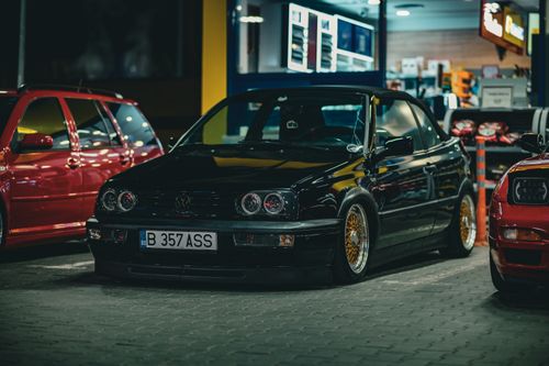 Free Black Volkswagen convertible parked at a gas station at night, showcasing sleek design and energy-efficient lighting. Stock Photo