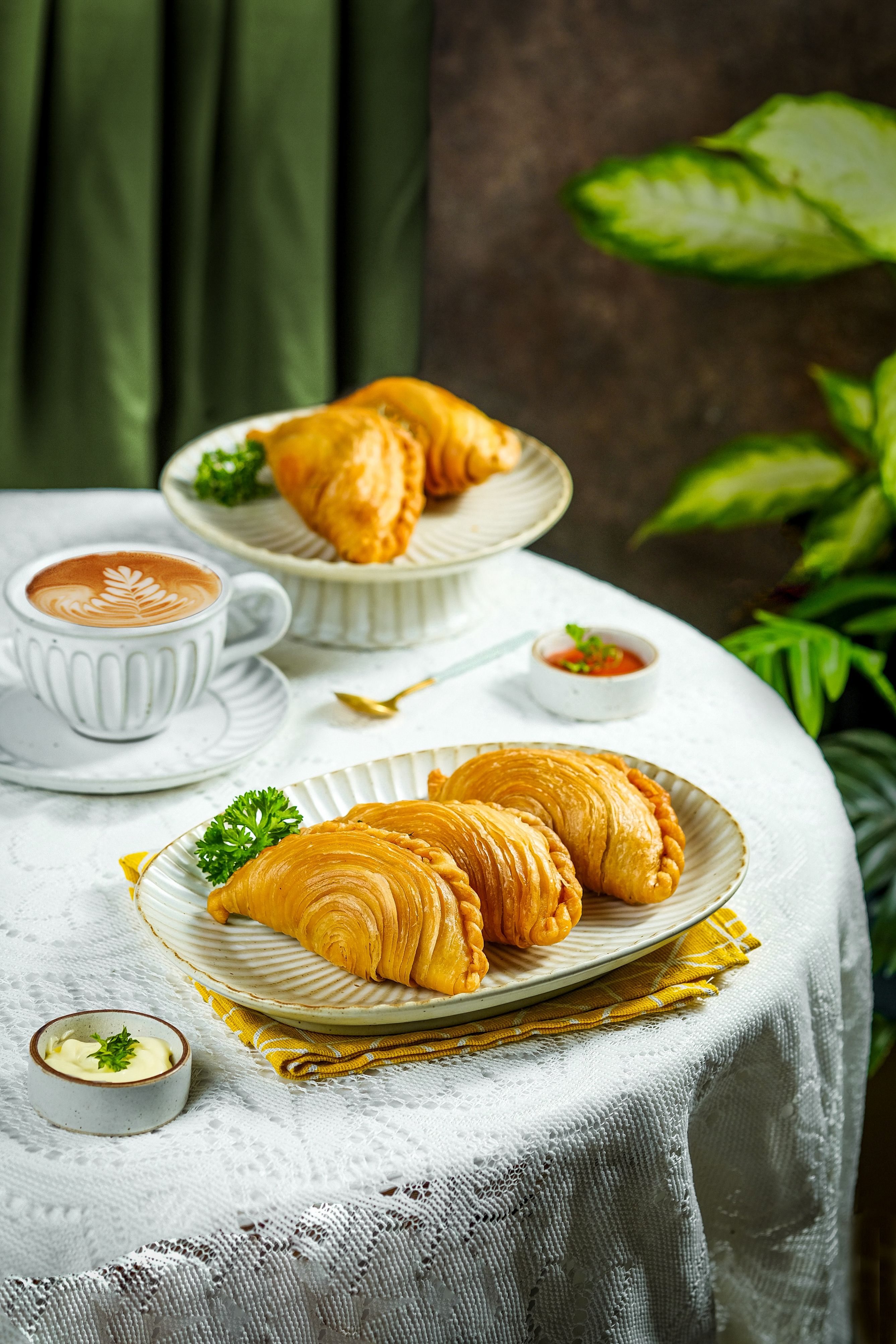 Gratuit Pâtisseries dorées accompagnées de café et de sauce, présentées sur une table élégamment dressée. Photos