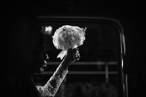Free A bride holding a floral bouquet, captured in black and white for an elegant and dramatic effect. Stock Photo