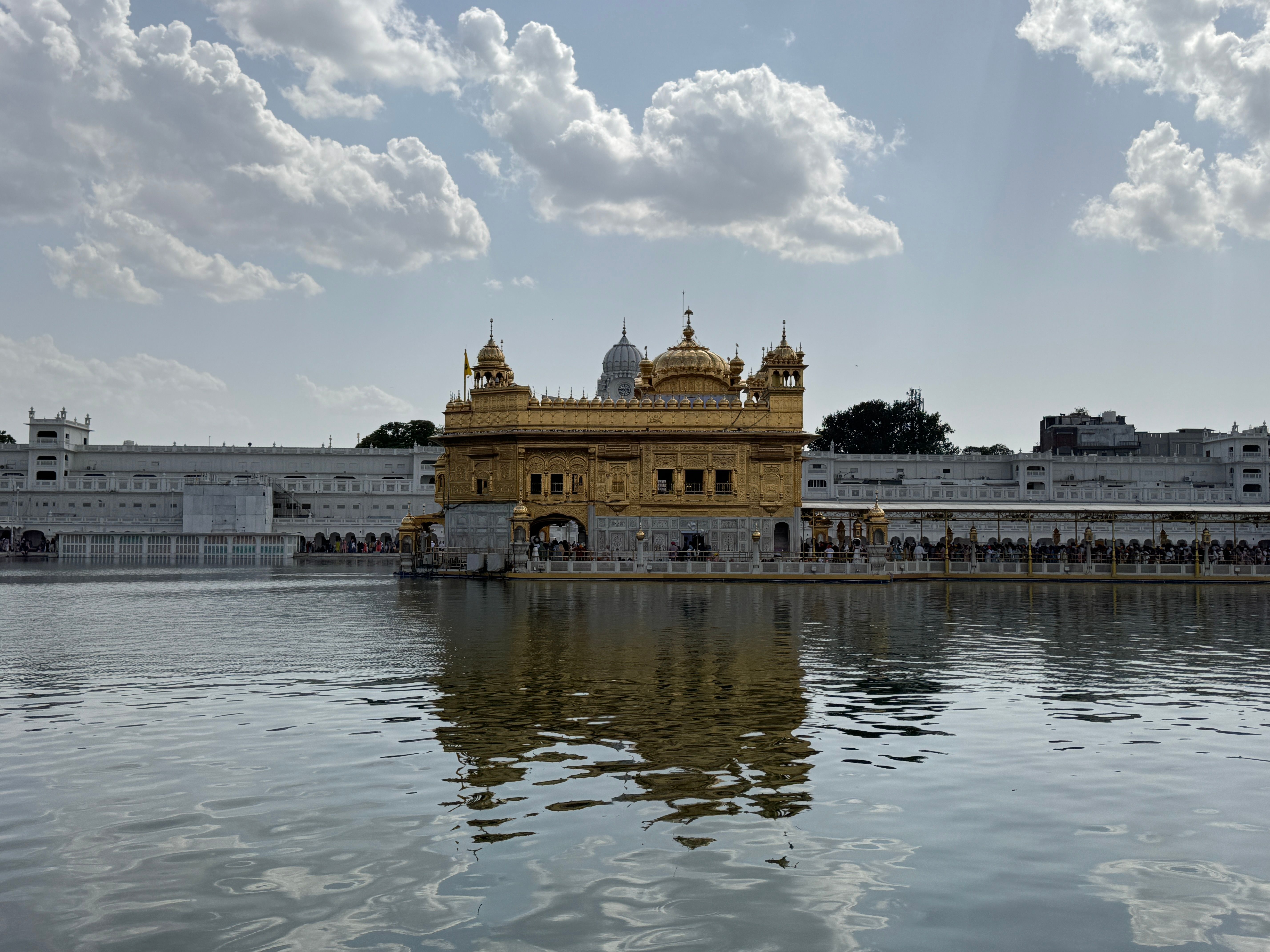 Silver doors and golden dome of Durgiana Temple reflected in its tank