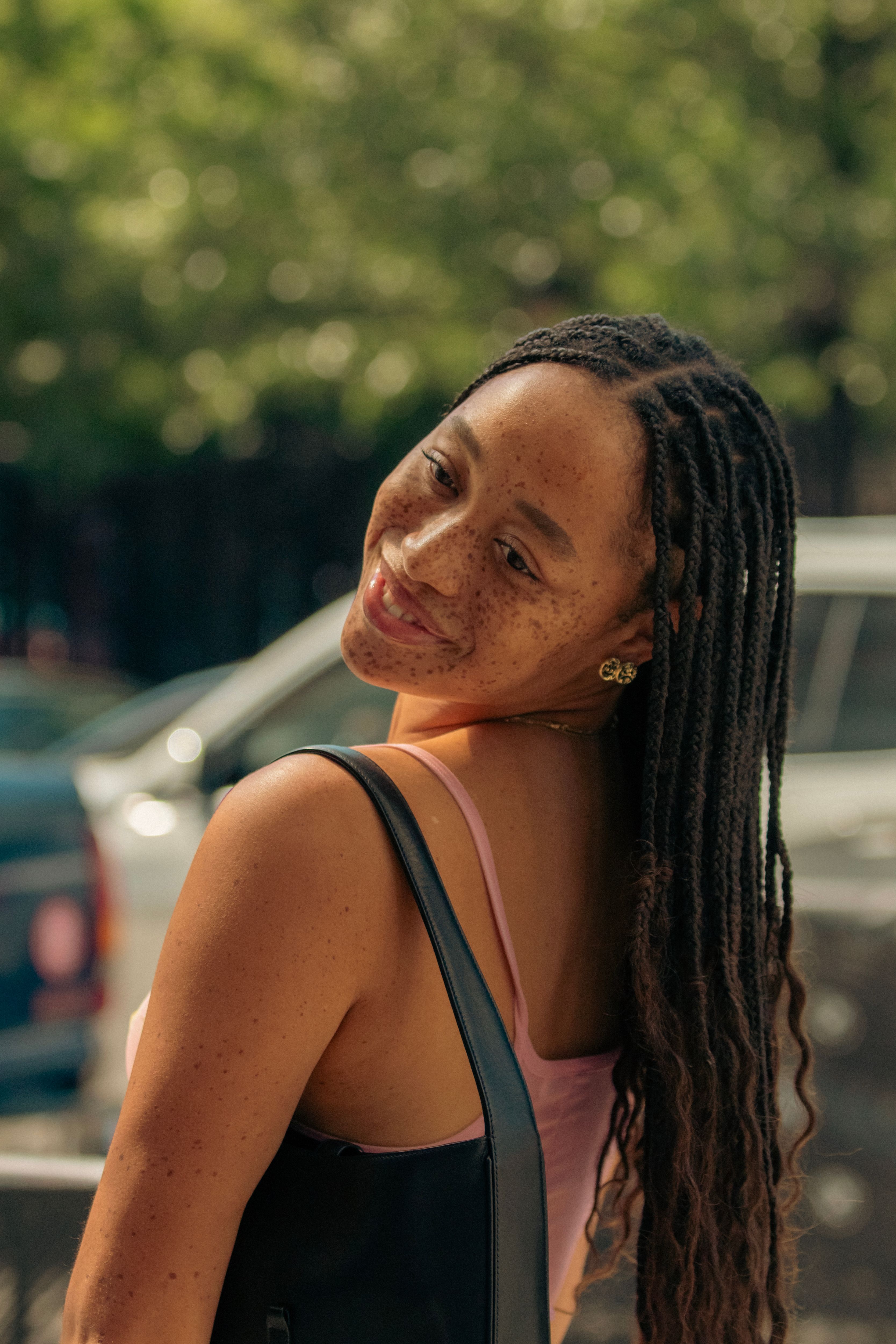 Smiling Woman with Braided Hair Outdoors · Free Stock Photo