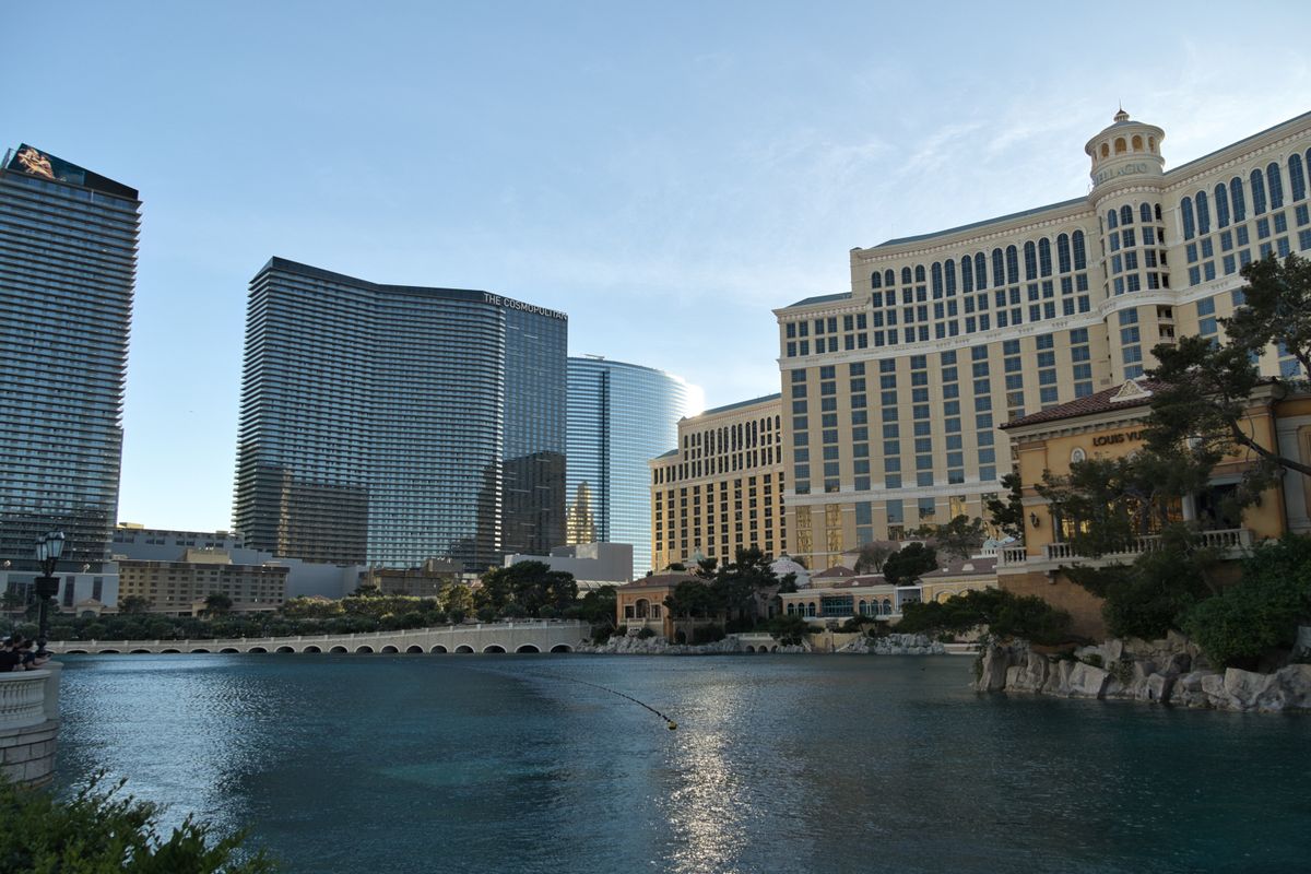 Resort towers and palm-lined lagoon along the Las Vegas Strip on a bright summer day.
