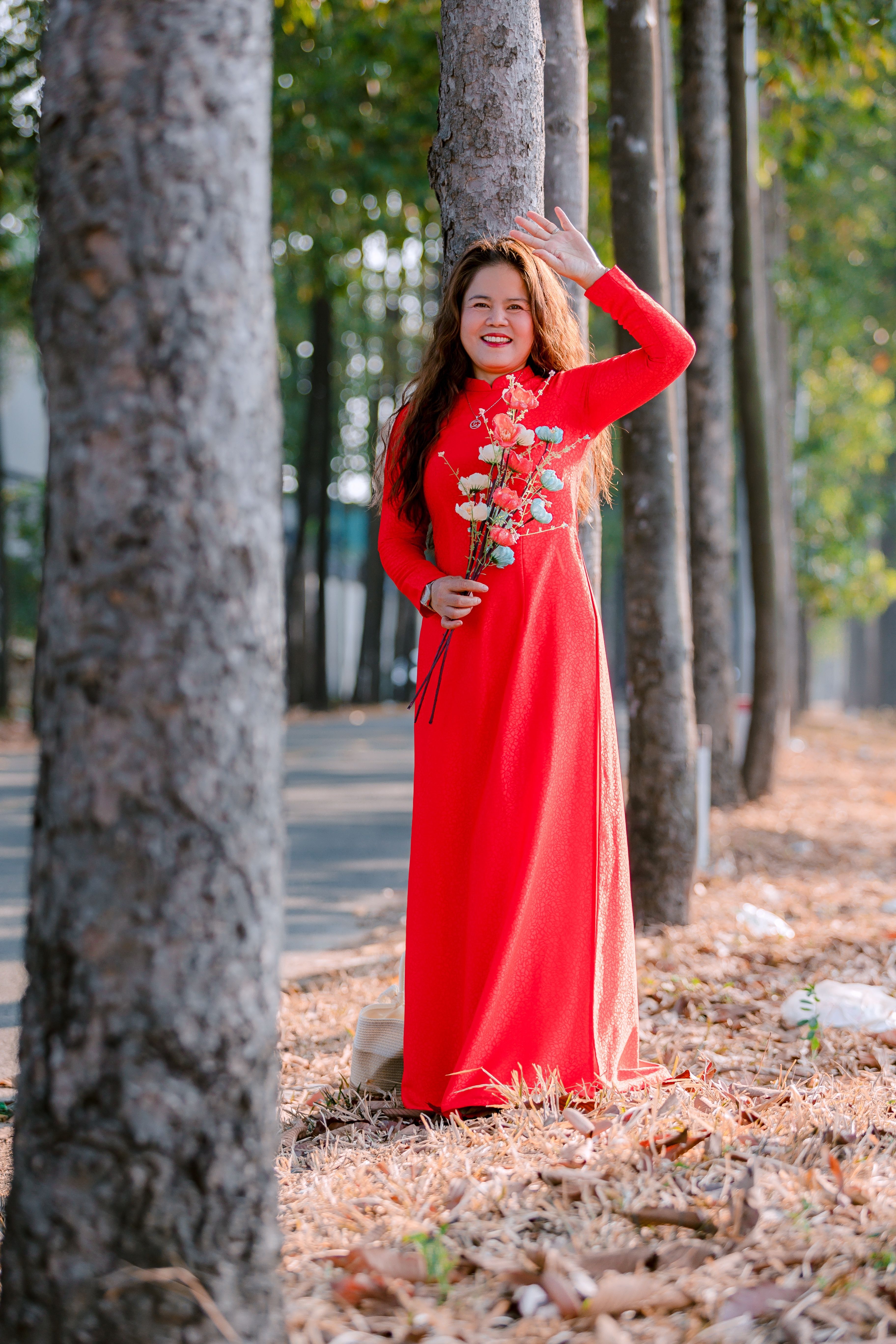 Woman in Red Dress Holding Flowers Outdoors · Free Stock Photo