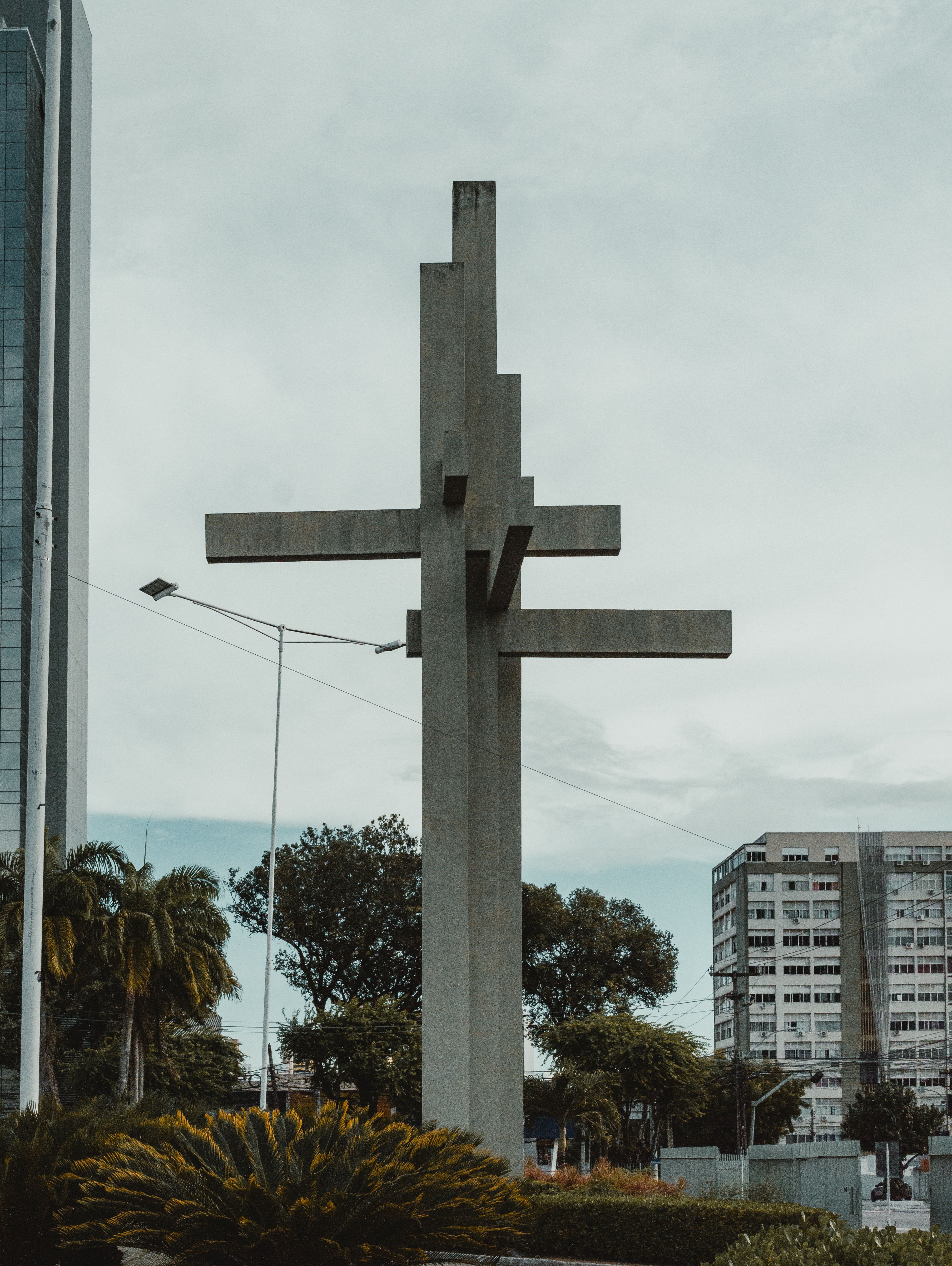 Concrete cross monument in Natal, Brazil, showcasing urban landscape and modern architecture.