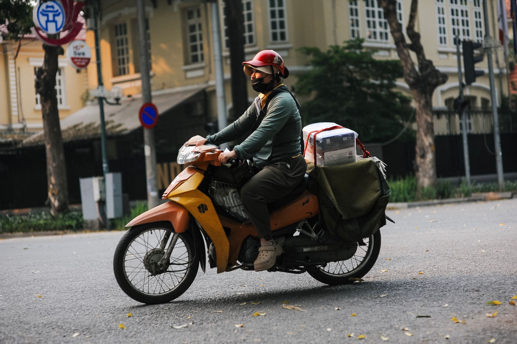 Helmeted motorcycle rider travelling through an urban environment