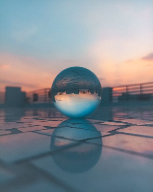 Free Stunning rooftop sunset reflected in a crystal ball creating an artistic surreal scene. Stock Photo