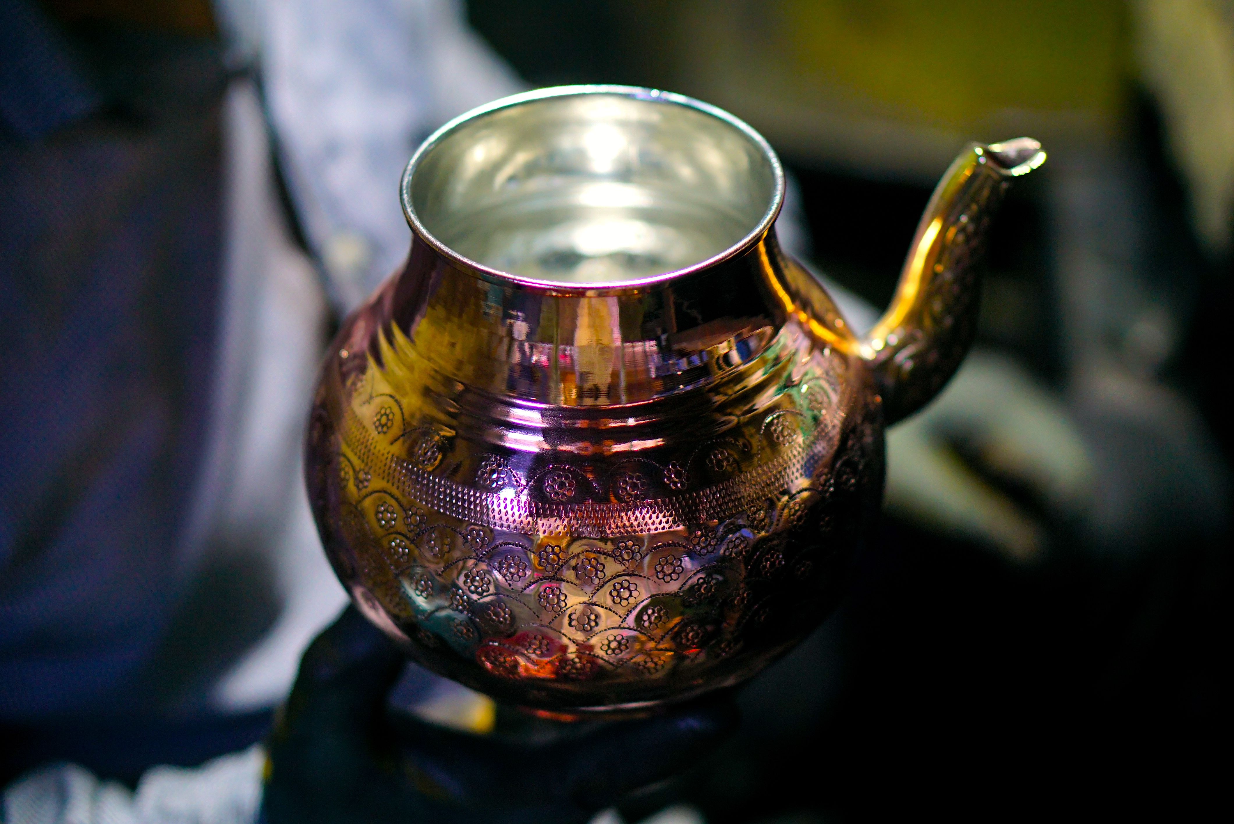 Handcrafted copper teapot with intricate patterns held by artisan in Gaziantep, Türkiye.