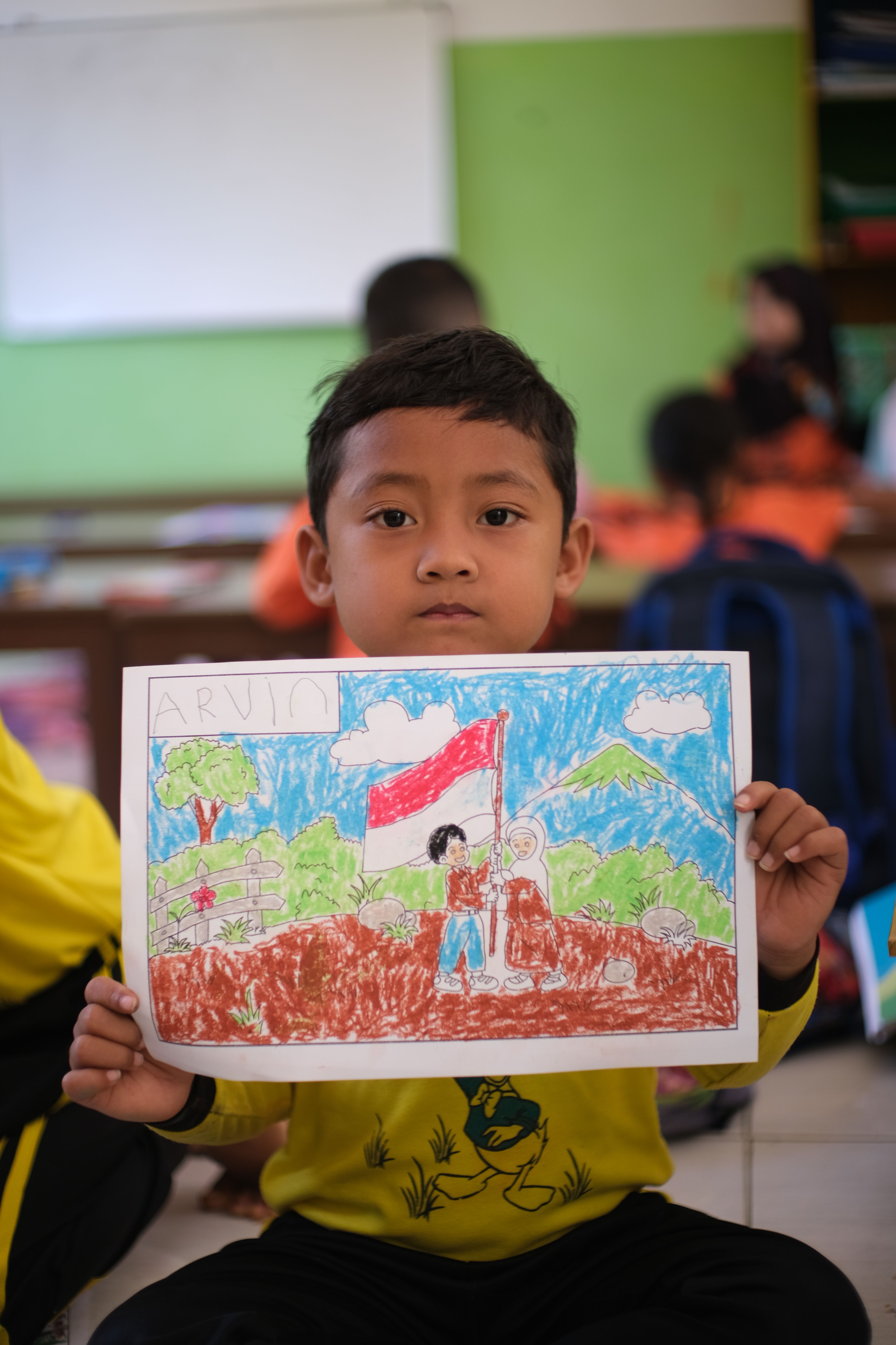 Anak di kelas menunjukkan gambar bertema bendera Indonesia