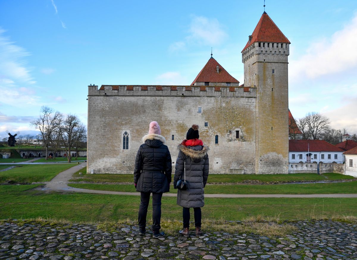 Doi vizitatori privind castelul din Kuressaare