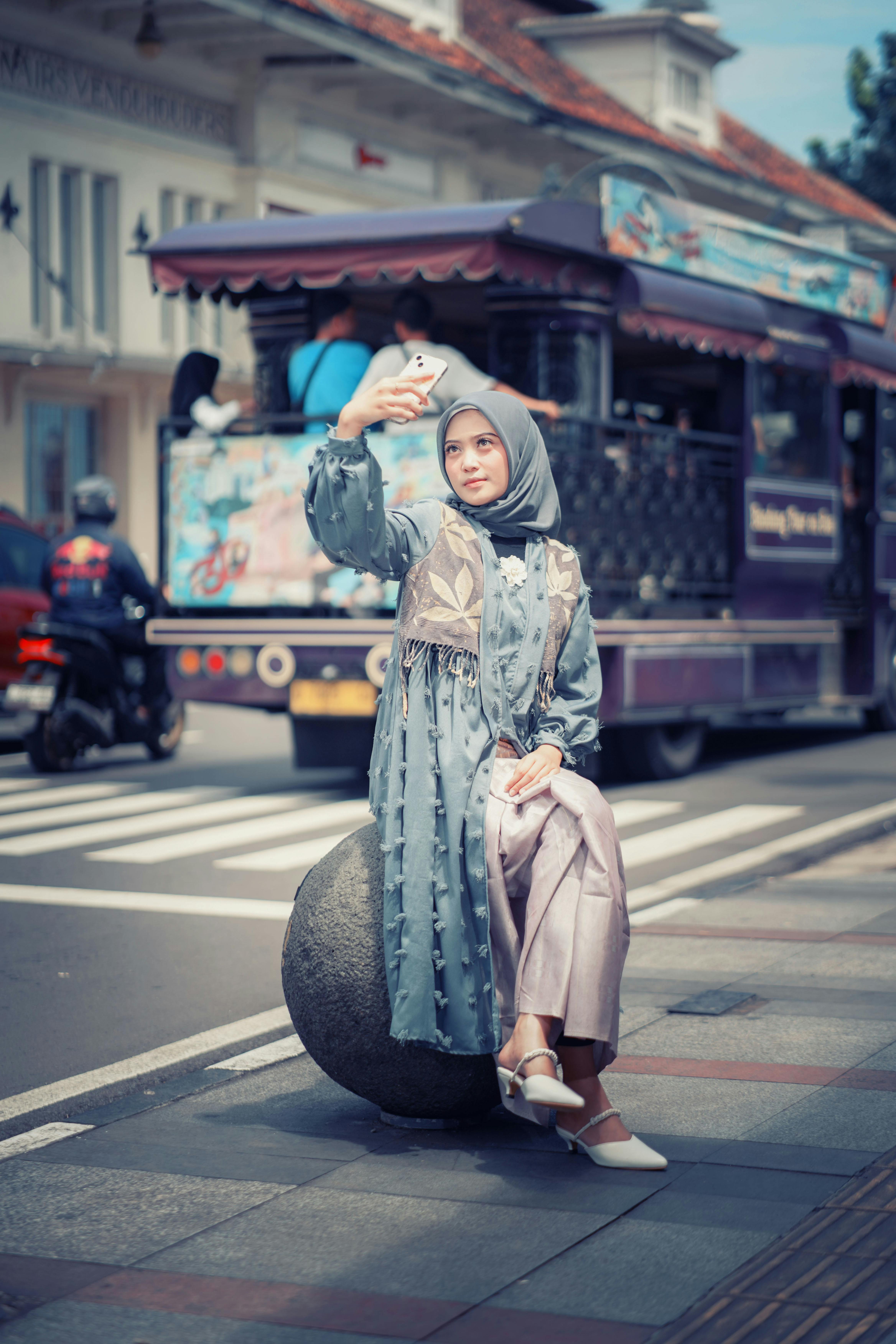 Stylish woman taking a selfie in the vibrant streets of Bandung, Indonesia.