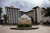 View of Masjid Istiqlal with its distinctive architecture and cloudy skies in Jakarta, Indonesia.