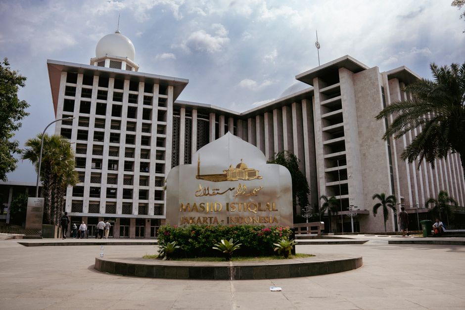View of Masjid Istiqlal with its distinctive architecture and cloudy skies in Jakarta, Indonesia.
