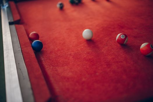 Close-up of a red pool table with vibrant billiard balls, ready for a game indoors.