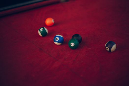 Vibrant billiard balls scattered across a red pool table, ready for a new game.