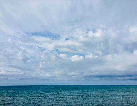 Scenic view of a calm ocean with expansive cloudy sky, perfect for tranquil themes.