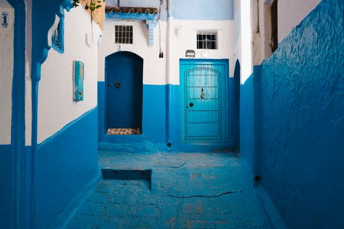 Free Explore the vibrant blue walls of Chefchaouen's architecture in this mesmerizing street scene. Stock Photo