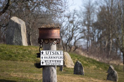 A rustic wooden signpost guides visitors in Gränna, Sweden, amidst an early spring setting.
