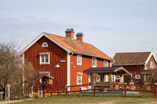 Free Scenic view of a classic red wooden house in Sweden, evoking cozy Nordic charm and picturesque countryside living. Stock Photo