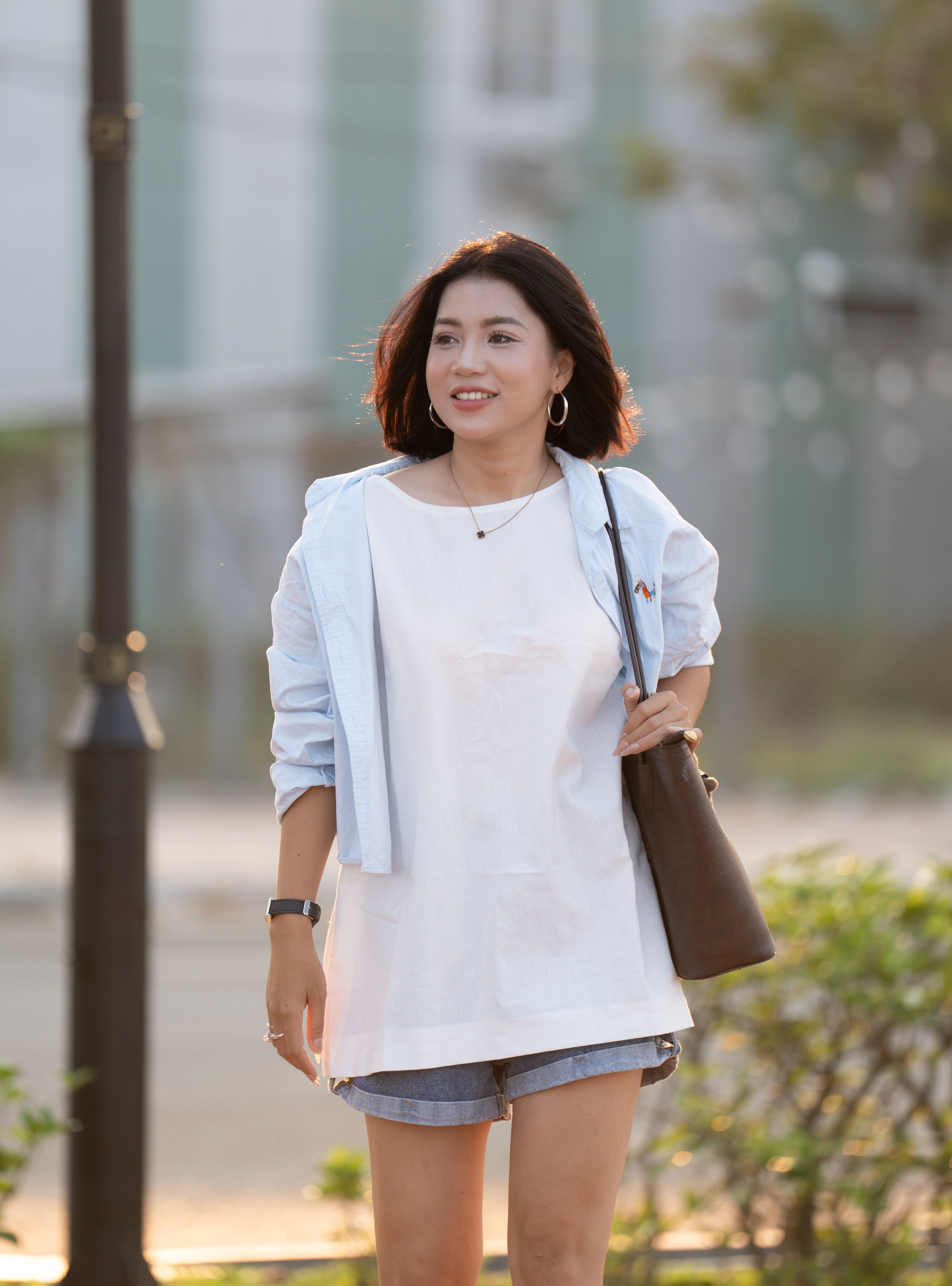 Smiling Woman Walking Outdoors in Casual Outfit · Free Stock Photo