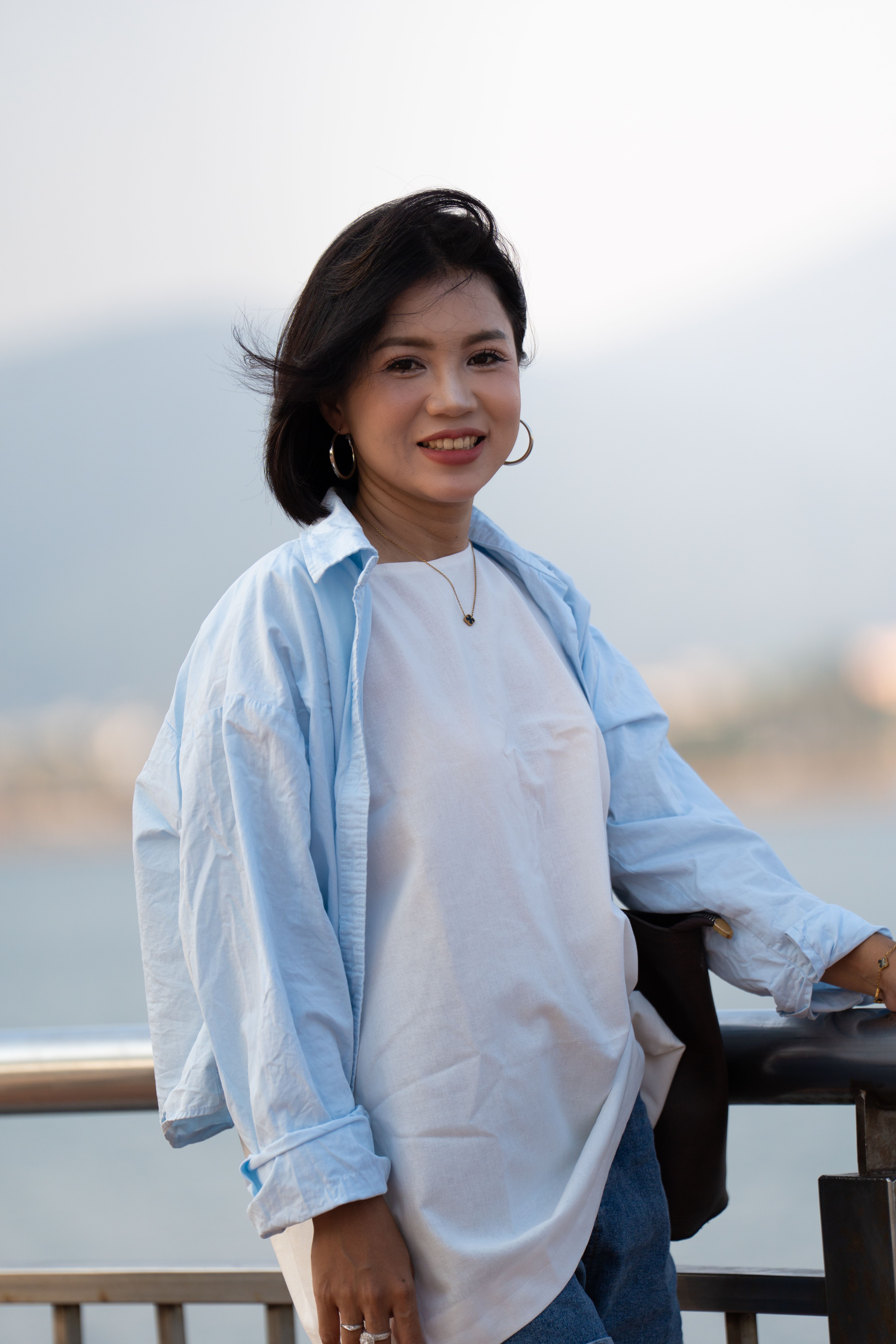 Smiling Woman Posing Outdoors by Waterfront · Free Stock Photo