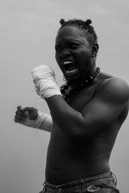 Fotomural Retrato dinámico en blanco y negro de un luchador decidido con los puños vendados, que muestra emoción e intensidad en estado puro.