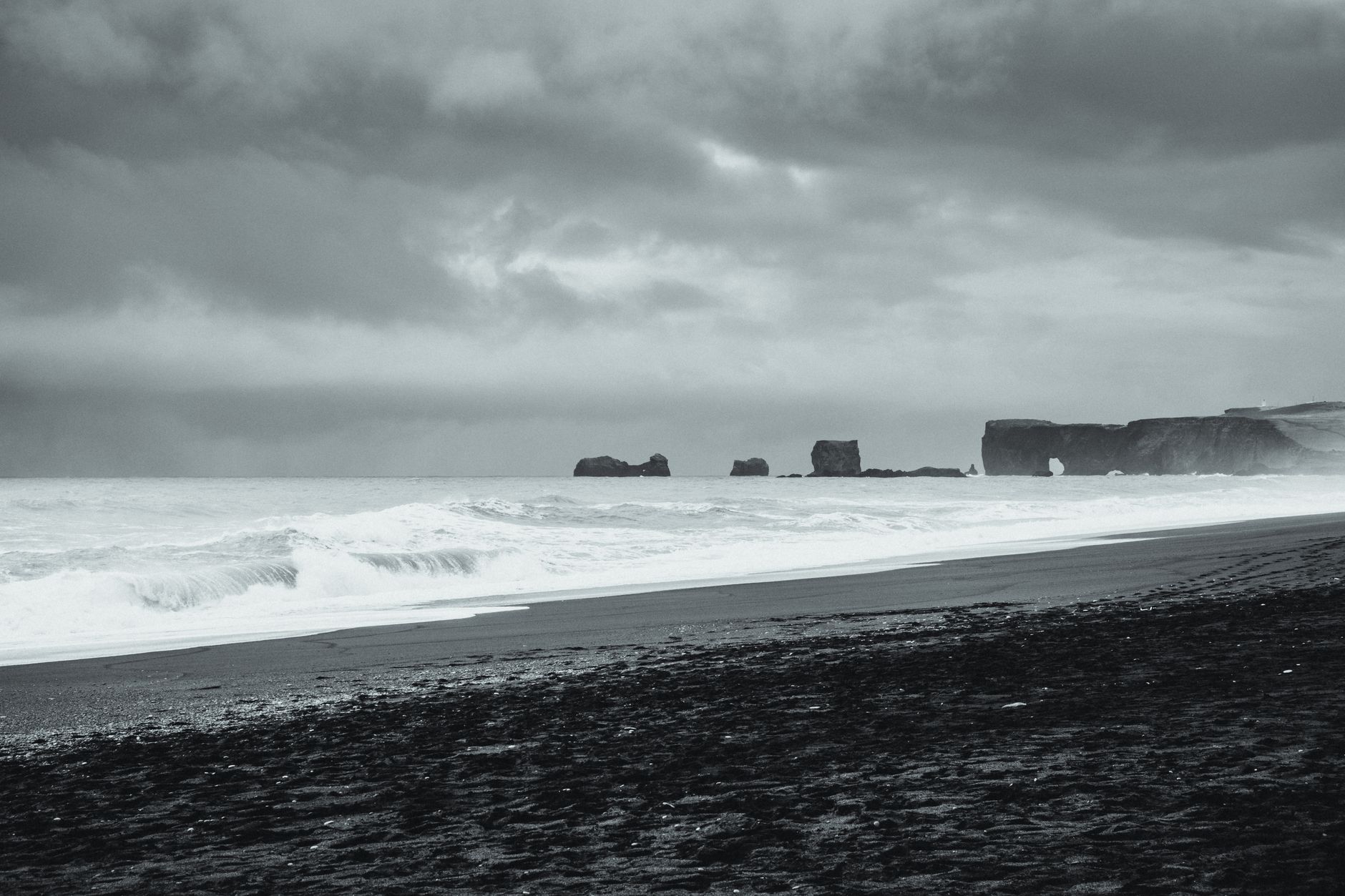 Moody black and white image of Iceland's black sand beach with dramatic waves under stormy skies.. pexels, moody, black