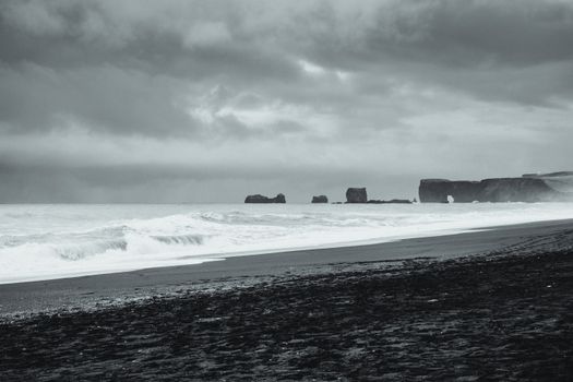 Moody black and white image of Iceland's black sand beach with dramatic waves under stormy skies.. pexels, moody, black