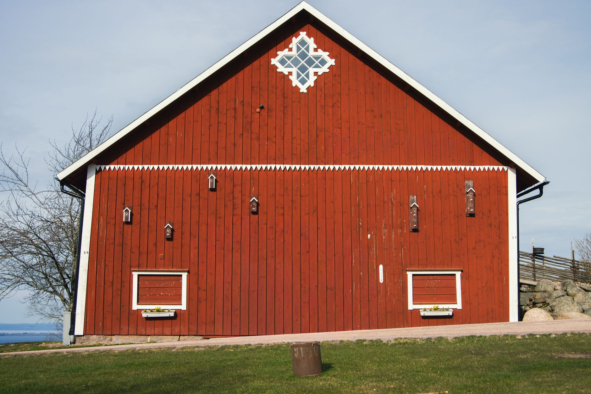 Classic red wooden barn in Swedish landscape during daylight.