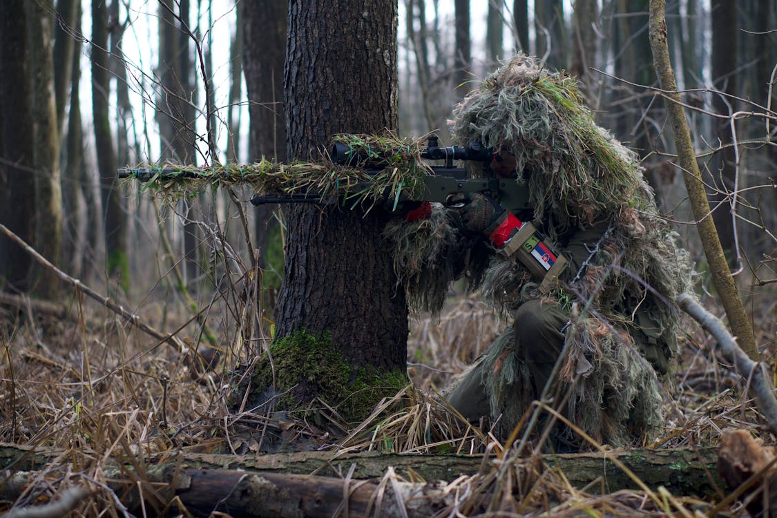 Free A Soldier Sniper Aiming Though The Rifle Scope In Forest Stock Photo