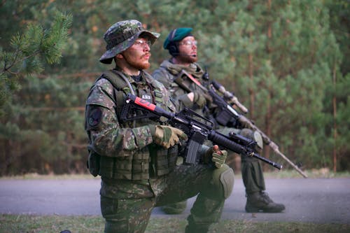 бесплатная Двое мужчин в зеленой камуфляжной форме с винтовкой Стоковое фото