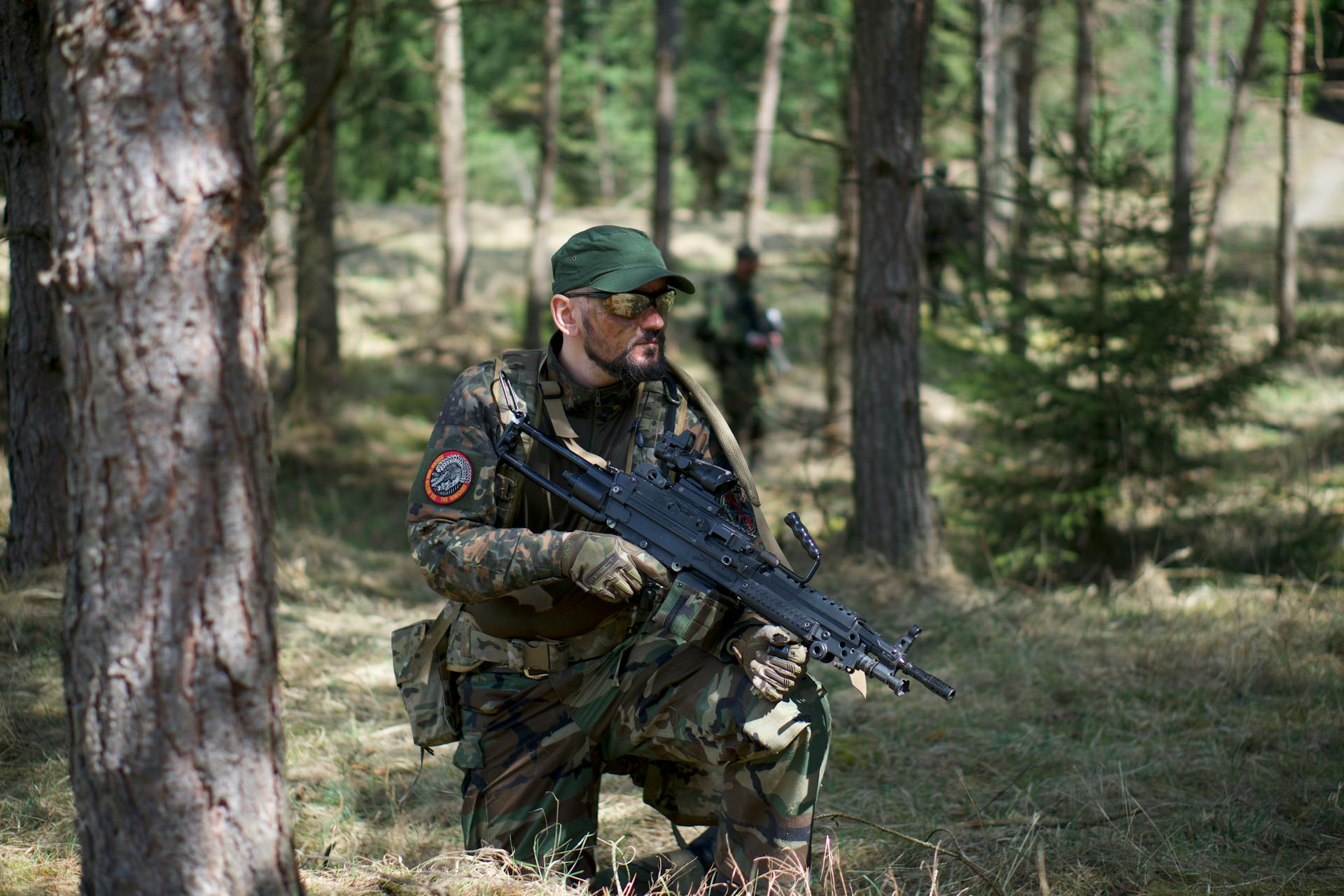 Man in Green and Brown Camouflage Army Uniform Holding a Rifle