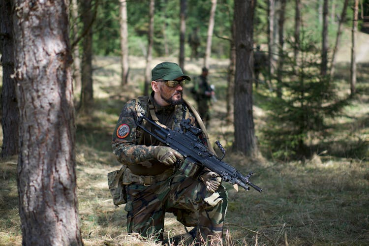 Man In Green And Brown Camouflage Army Uniform Holding A Rifle