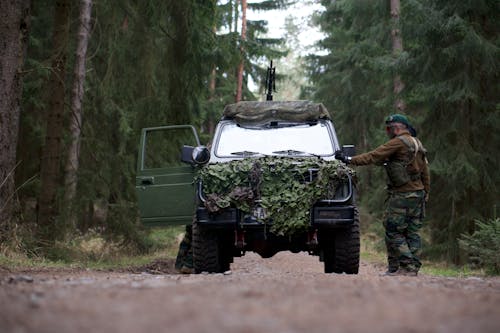 Army Official  Standing Beside Green Off road Car