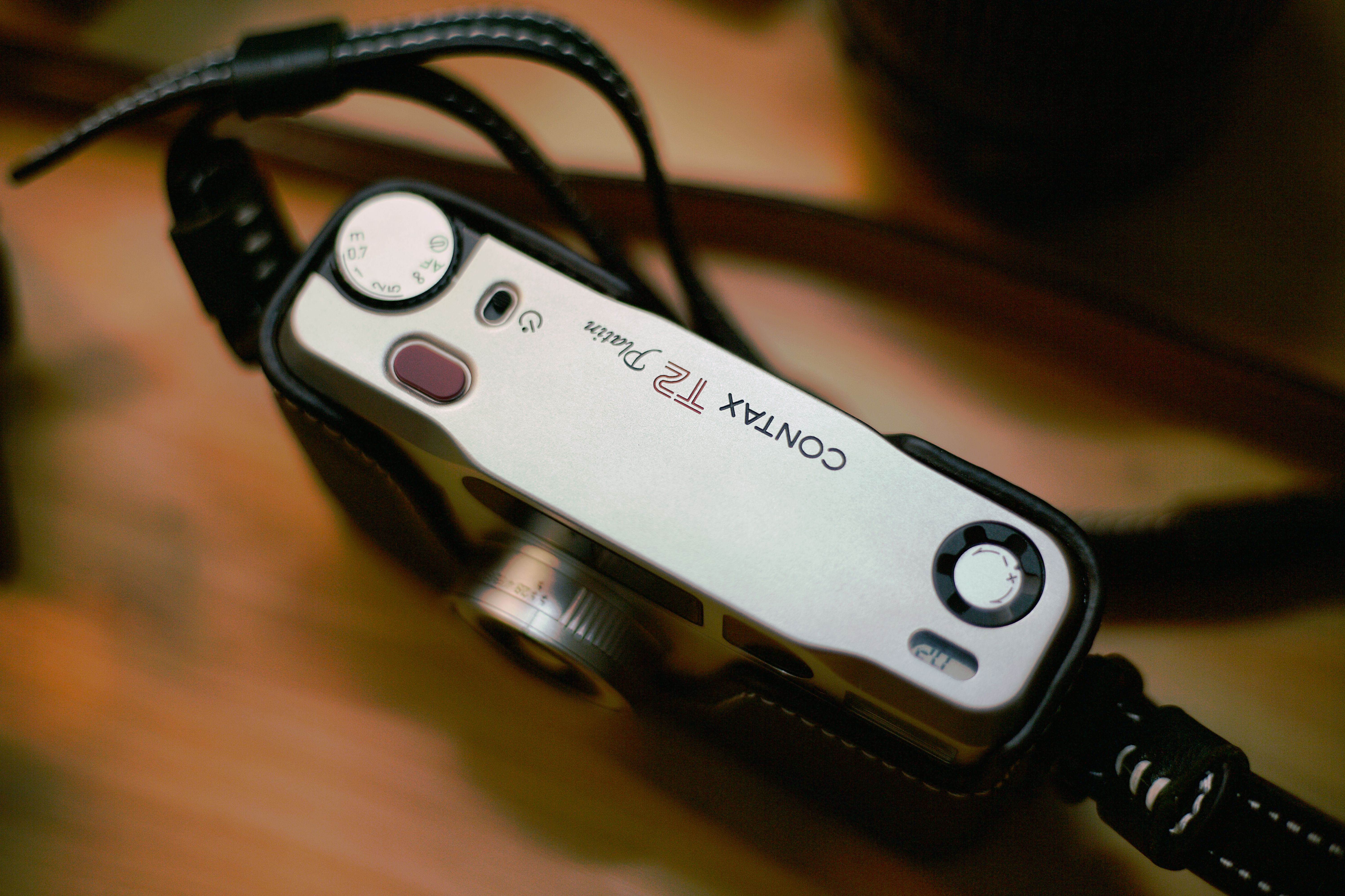 High-quality close-up of a vintage Contax T2 film camera in a classic leather case, evoking nostalgia.