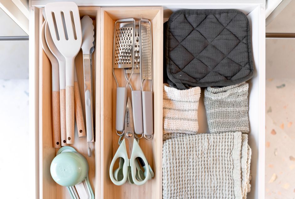 Neatly arranged kitchen tools and textiles in a drawer, showcasing an organized culinary space.