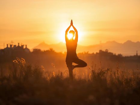 A person practicing yoga outdoors at sunset, capturing a serene and peaceful moment.