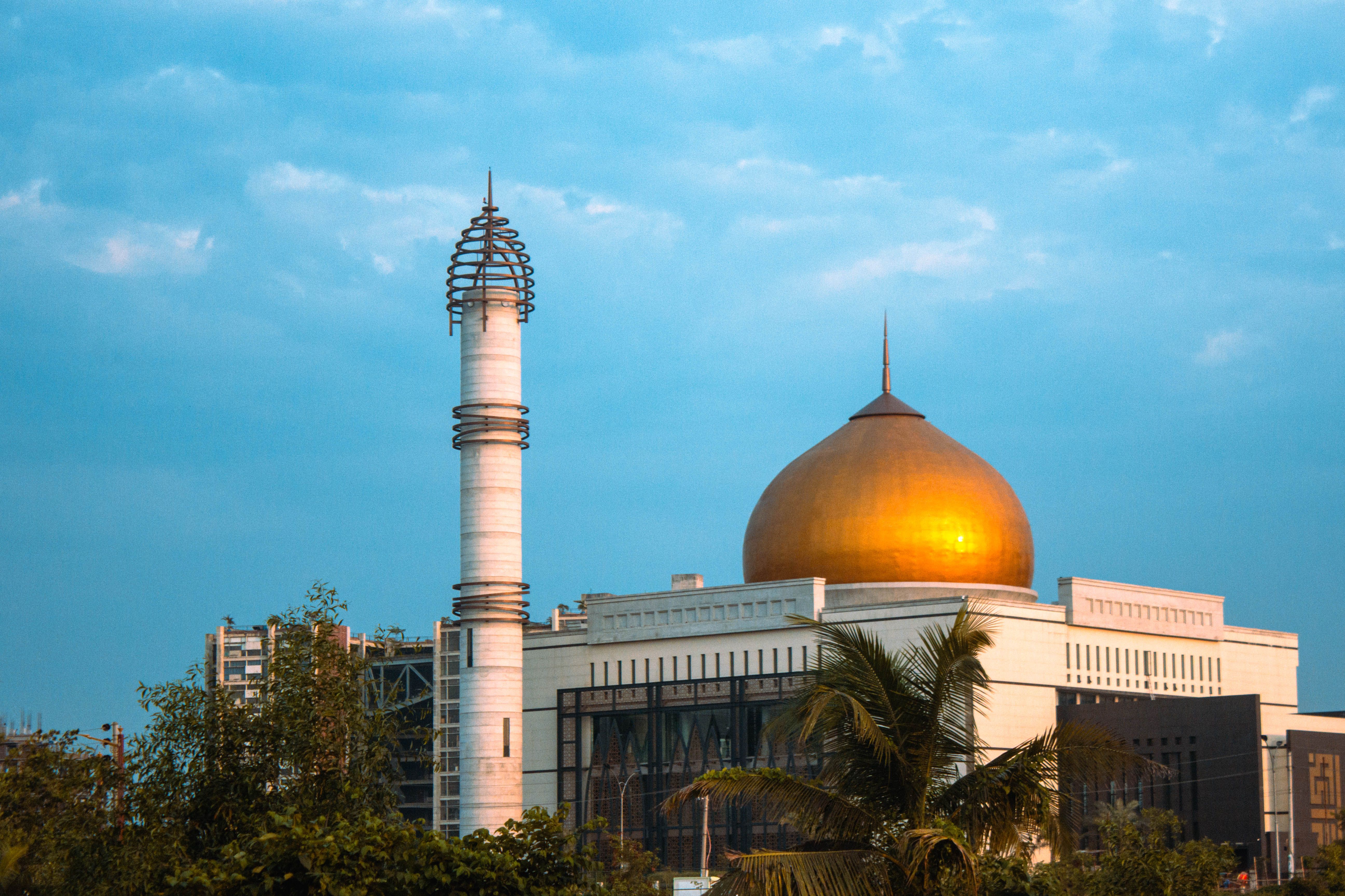 Stunning view of a golden-domed mosque and minaret in Dhaka, Bangladesh at sunset.