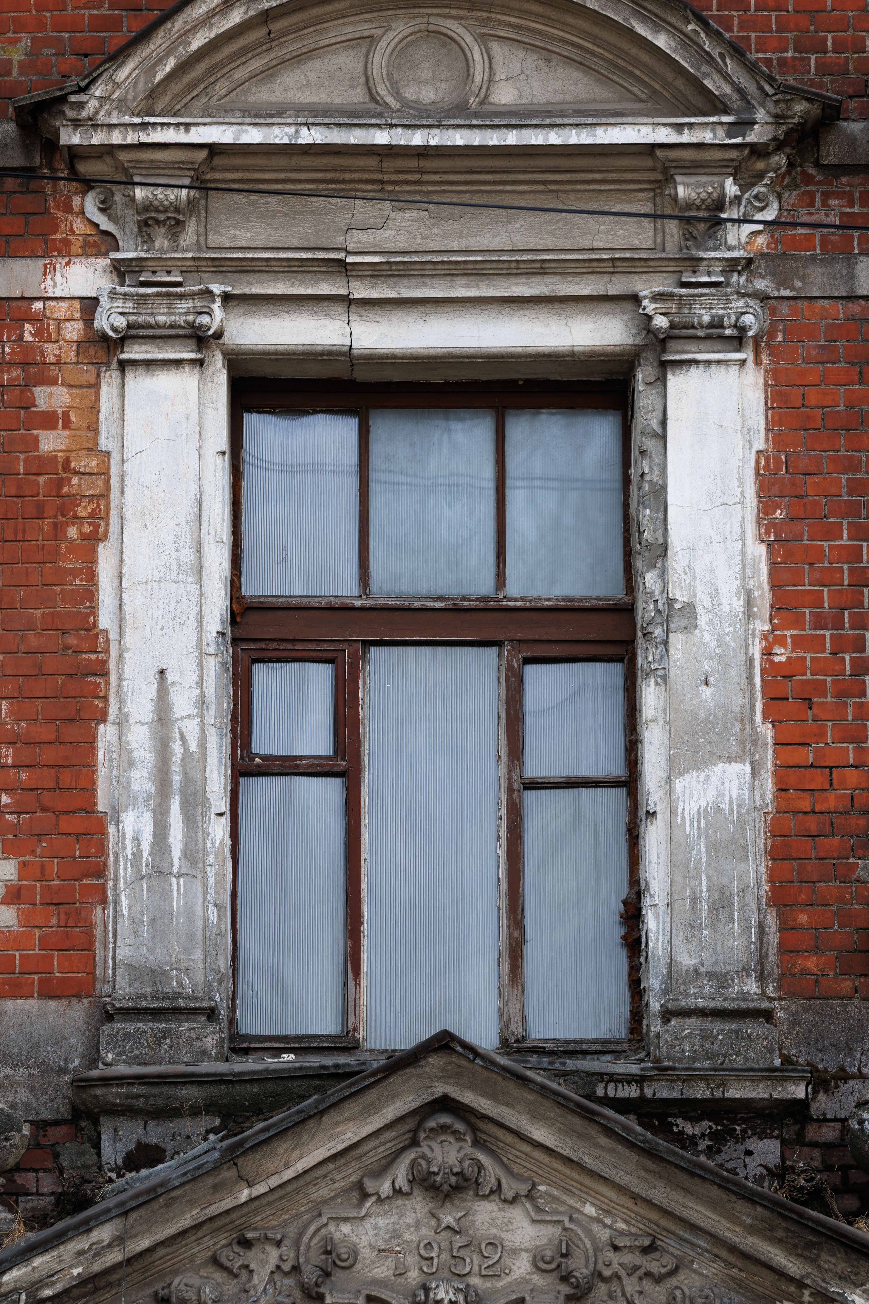 Close-up of an ornate historic window with red bricks and stone details in Kaliningrad, Russia.